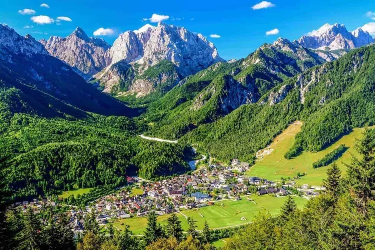 Panoramski pogled na Kranjsku Goru u zelenoj alpskoj dolini ispod Julijskih Alpa